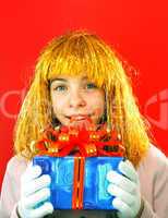 Teen girl with a present against red background