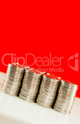 Coins stacked in bars against red background