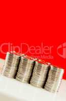 Coins stacked in bars against red background