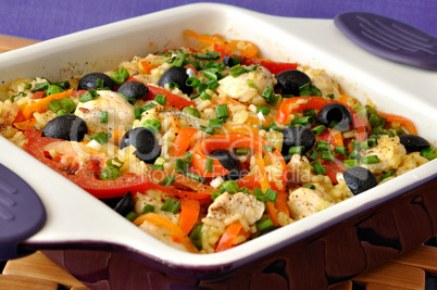 Baked rice with chicken, vegetables and olives in a saucepan