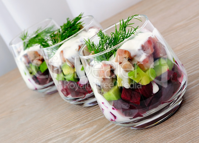 Appetizer in a glass of beet and herring with avocado