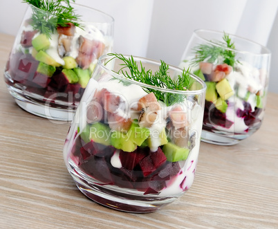 Appetizer in a glass of beet and herring with avocado