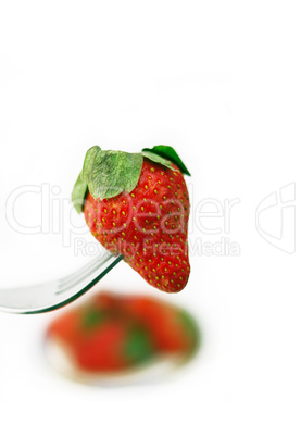 fresh strawberry  on a fork over white