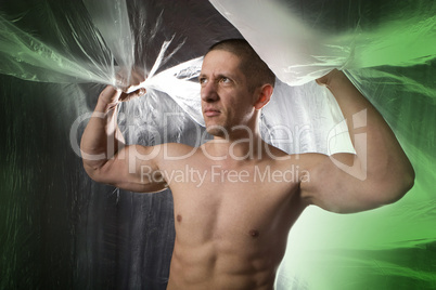 Muscular young man on green abstract green background