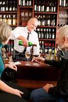 Wine bar senior couple barman pour glass