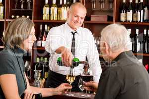Wine bar senior couple barman pour glass