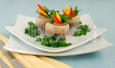 Rolls of herring with pickled cucumber and pepper