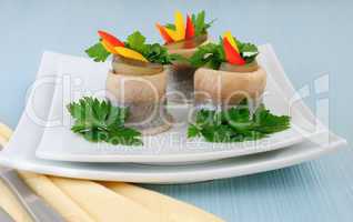 Rolls of herring with pickled cucumber and pepper