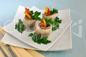 Rolls of herring with pickled cucumber and pepper