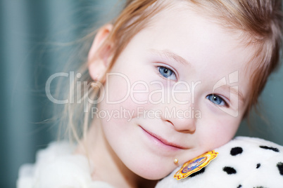 portrait of a beautiful little girl with a toy dog