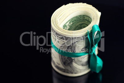 Dollars rolled into a tube on black background