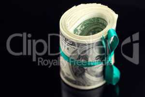 Dollars rolled into a tube on black background
