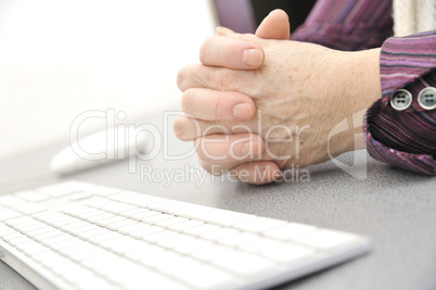 Hands of an old female typing on the keyboard, isolated on white, close-up.