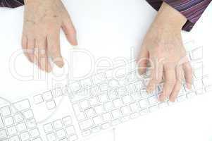Hands of an old female typing on the keyboard and using mouse, isolated on white, close-up.