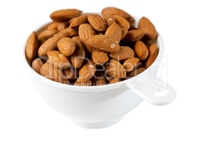 Raw organic almonds in measuring cup