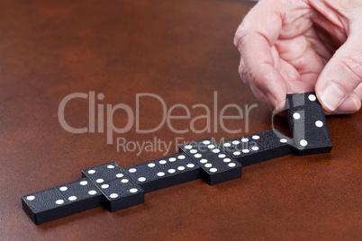 Game of dominoes on leather table