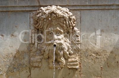 Funny mascaron face on fountain in Alhambra, Granada, Spain