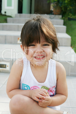 Beautiful girl sitting outdoors smilling