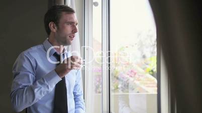 Businessman drinking coffee and looking out of window