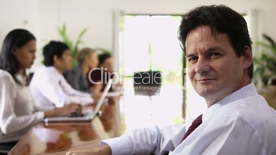 Mature caucasian businessman looking at camera during business conference