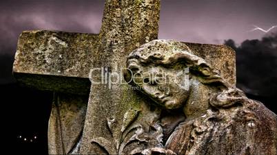 Lightning strikes over graveyard statue