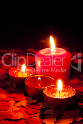 Four burning candles over red background