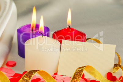 Three burning candles over light background