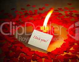 Burning heart shaped candle and a card