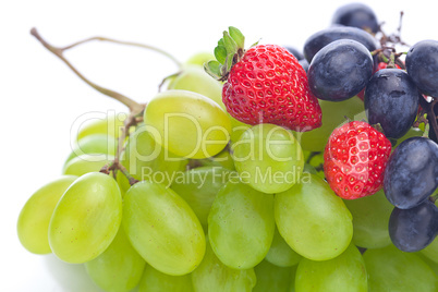 bunch of white and black grapes and strawberries isolated on whi