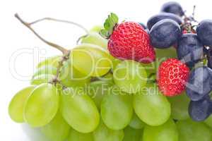 bunch of white and black grapes and strawberries isolated on whi