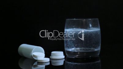 effervescent tablet of aspirin in a glass of water. slider shot.