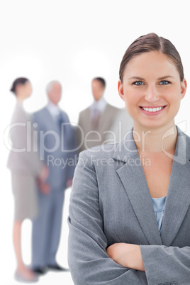 Smiling businesswoman with her colleagues behind her