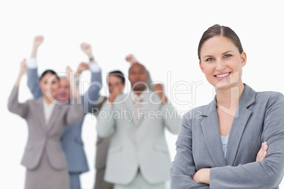 Smiling businesswoman with cheering team behind her
