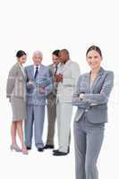 Smiling tradeswoman with arms folded and team behind her