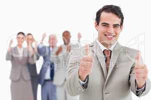 Salesman with team behind him giving thumbs up