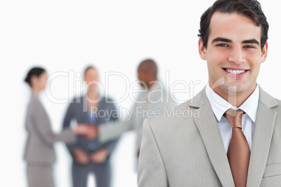 Smiling man of business with trading partners behind him