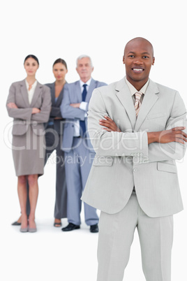 Smiling tradesman with arms folded and team behind him