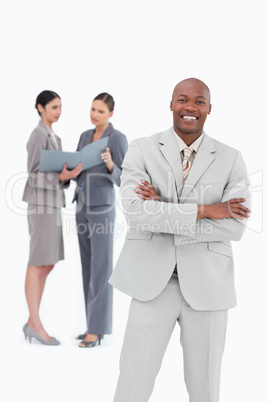 Smiling businessman with co-workers behind him