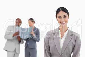 Smiling saleswoman with co-workers behind her