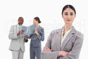 Smiling tradeswoman with arms crossed and team behind her