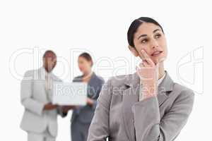 Businesswoman in thoughts with colleagues behind her