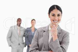 Smiling businesswoman with associates behind her