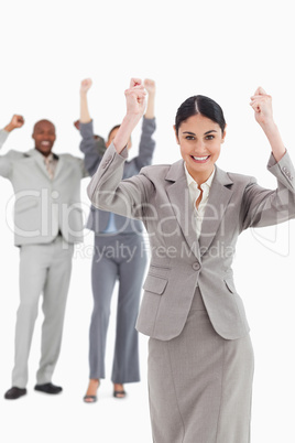 Triumphant saleswoman with cheering associates behind her