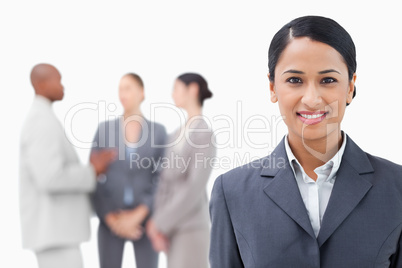 Businesswoman with talking associates behind her