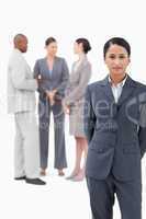 Businesswoman with negotiating trading partners behind her