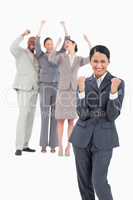 Successful saleswoman with cheering team behind her