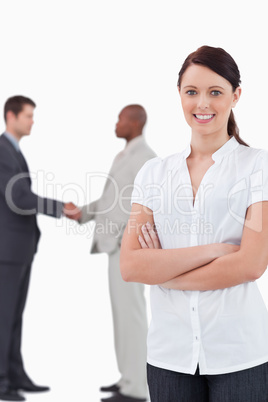 Tradeswoman with arms folded and hand shaking trading partners b