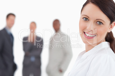 Smiling businesswoman with three colleagues behind her