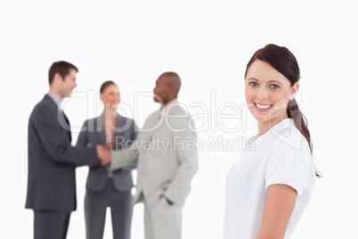 Smiling saleswoman with three colleagues behind her