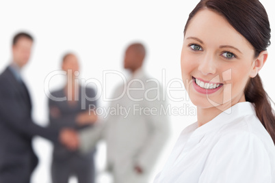 Smiling businesswoman with three associates behind her